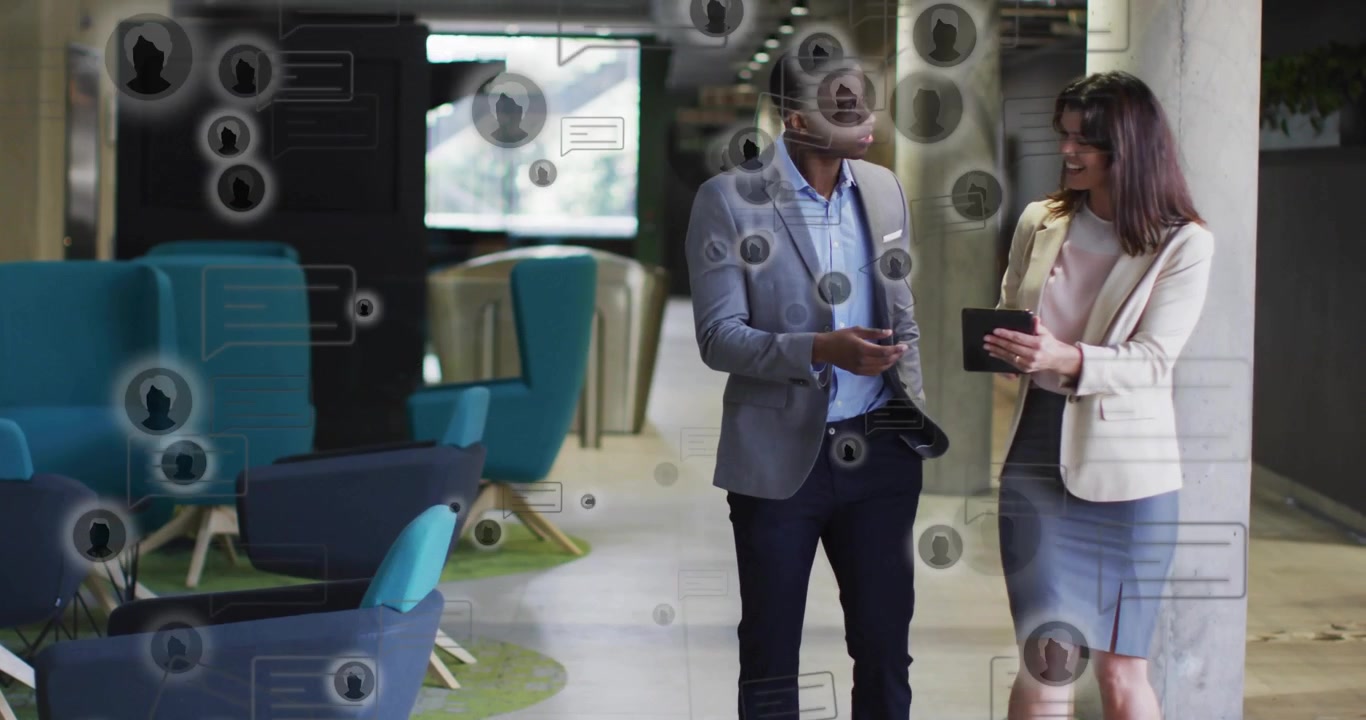 Man pointing at tablet starting data overlay while woman scrolling tablet, reviewing business KPIs