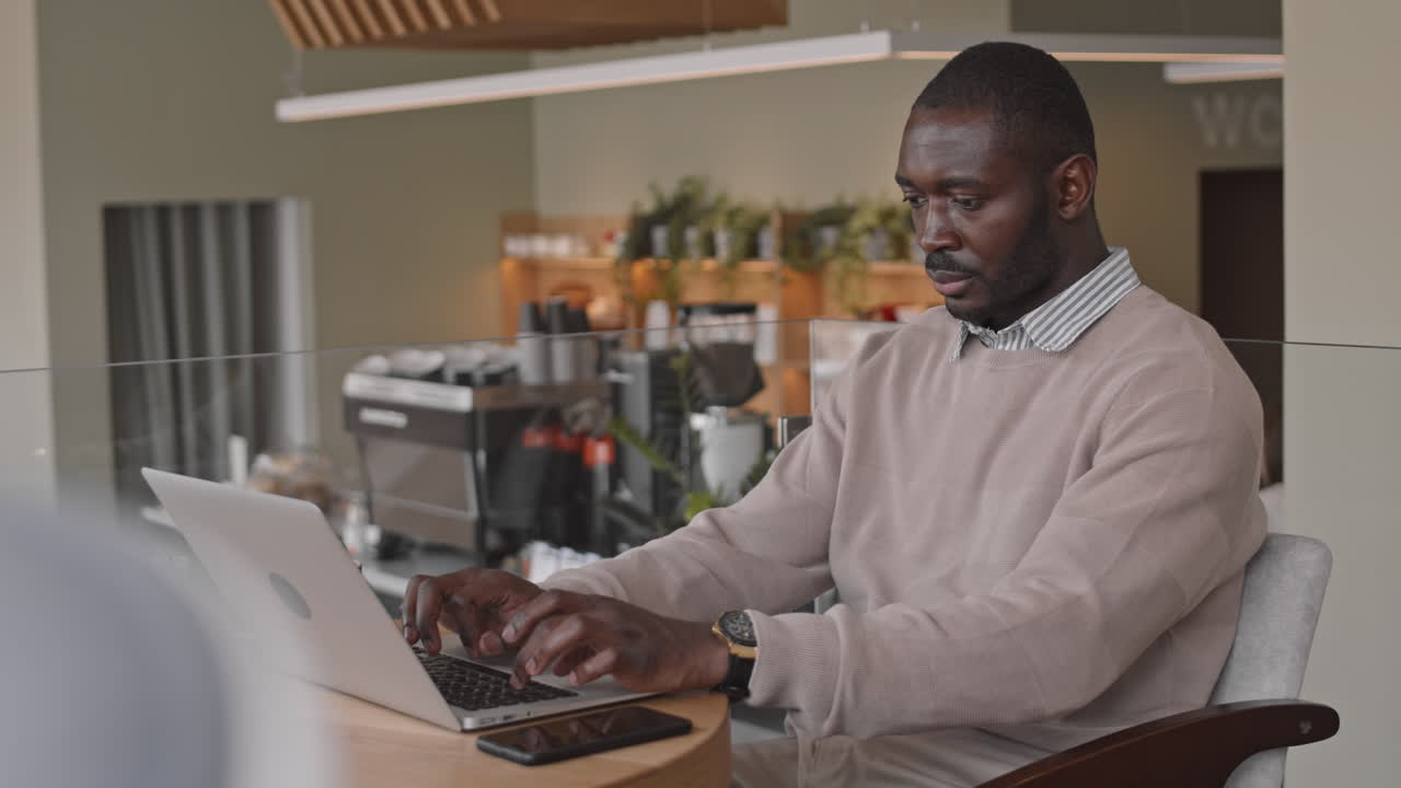 Businessman Working on Laptop in Coffee Shop