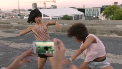 chicas jóvenes bailando en la calle siendo grabadas