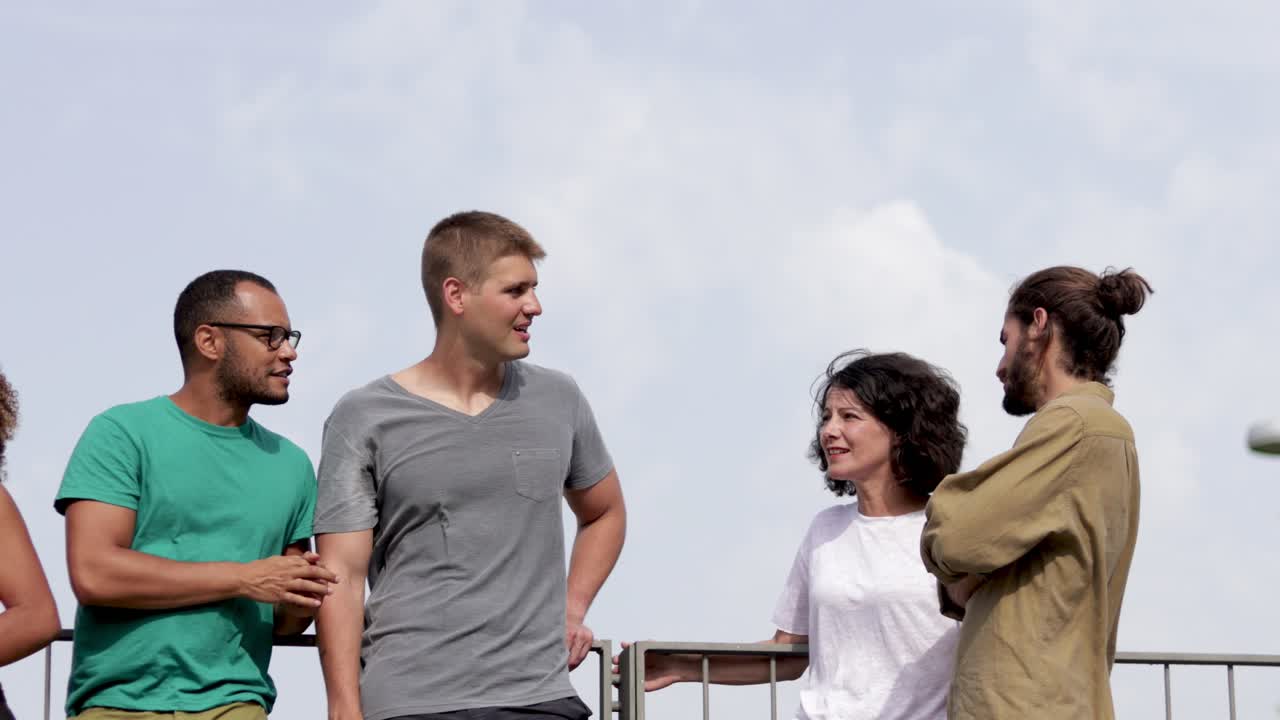 웃는 다민족 사람들이 야외에서 이야기하고 있습니다.