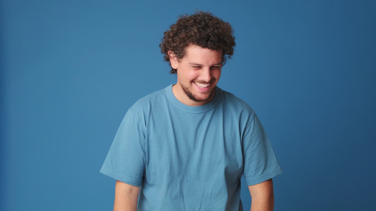 Young Man with Curly Hair Smiling and Laughing