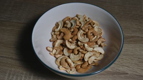 Zoom-In-Eine-Schüssel-Mit-Cashewnüssen-Auf-Dem-Tisch,-Eine-Gesunde-Proteinquelle-Und-Energienahrung