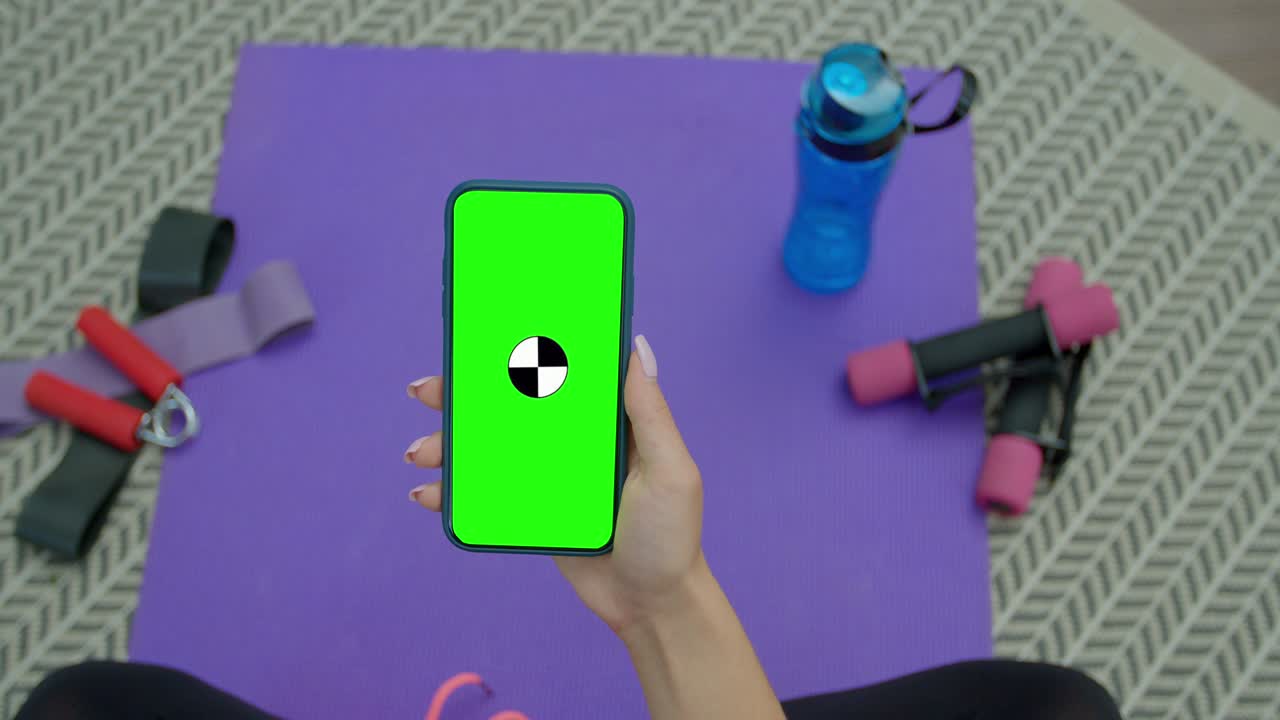 mujer de fitness usar teléfono inteligente con pantalla verde después de entrenar en casa. estilo de vida saludable. estiramiento, inclinarse hacia adelante. entrenamiento a distancia.