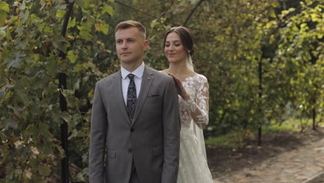 Lovely-newlyweds-caucasian-bride-embracing-groom-in-park-making-kiss,-wedding-couple-family-hugging