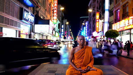 monje meditando en una concurrida calle de la ciudad por la noche