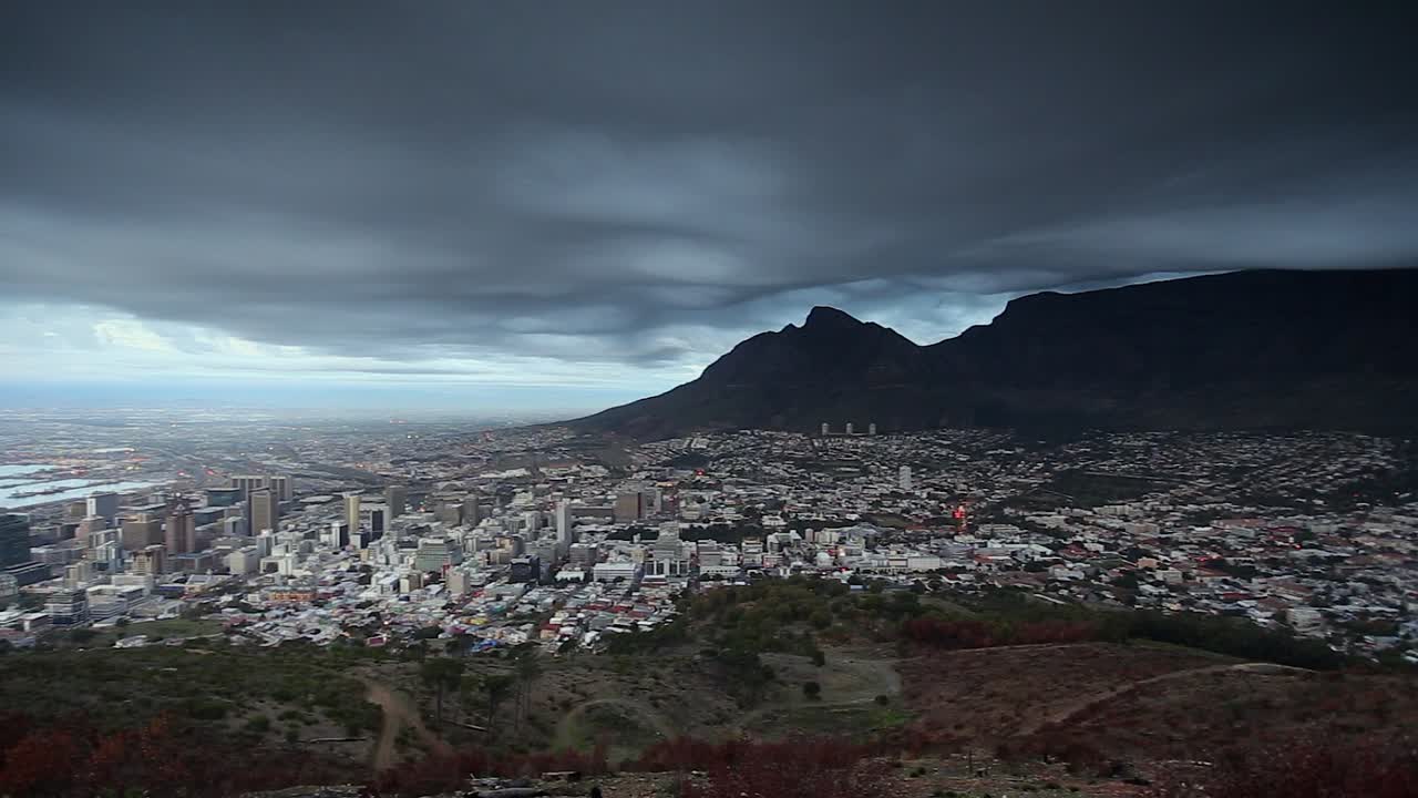 Panorâmica do porto à beira-mar até a Montanha da Mesa sob nuvens escuras, Cidade do Cabo