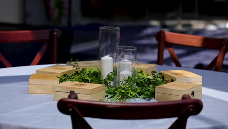 White-candles-in-vases,-ornamental-plants-on-the-table-in-the-restaurant