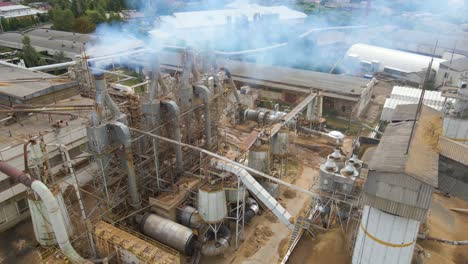 aerial view of wood processing plant with smokestack from production process polluting environment at factory manufacturing yard