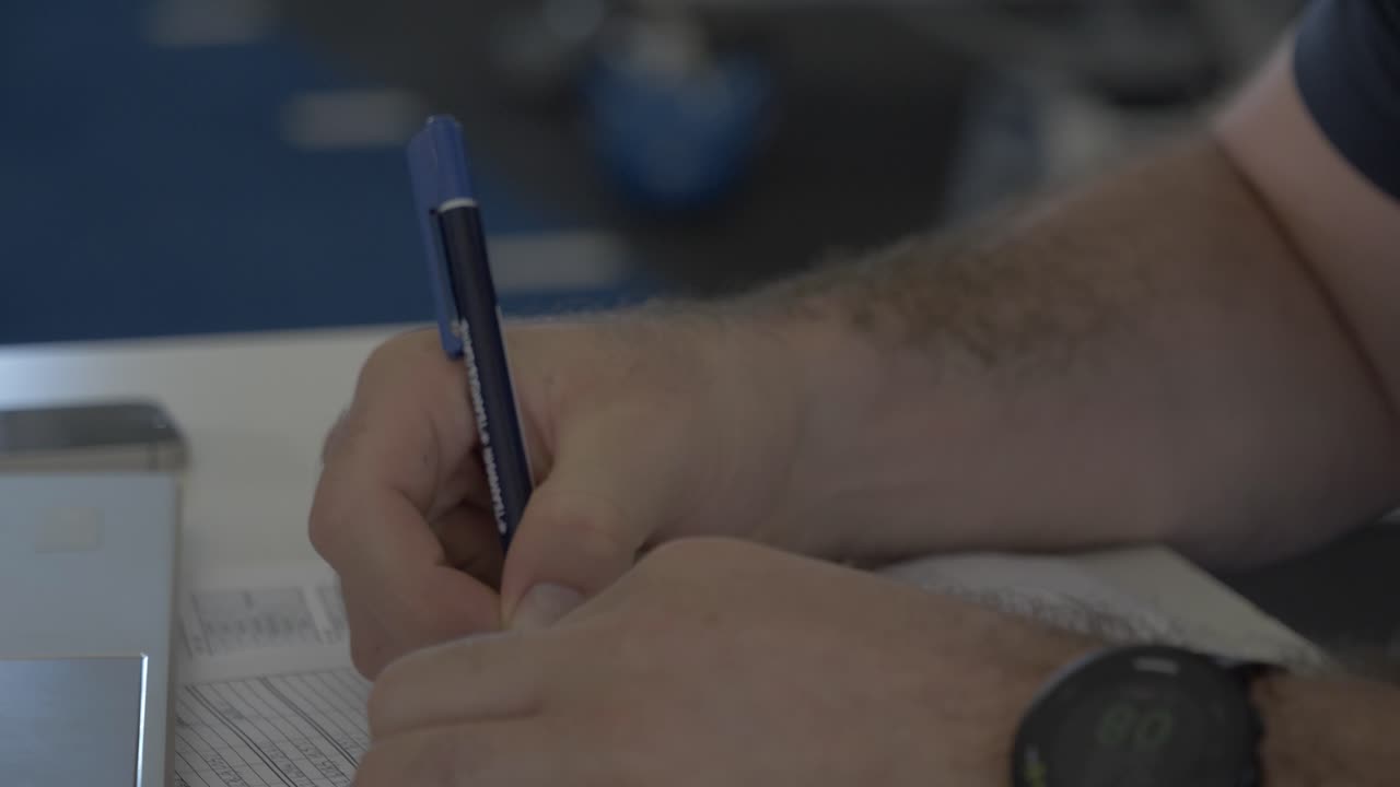 close up of a businessman filling in a form on his desk in a rugby gym in Montpellier, France