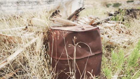 rusty barrel in a field of debris