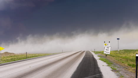 dust clouds quickly blow across a road in stormy conditions