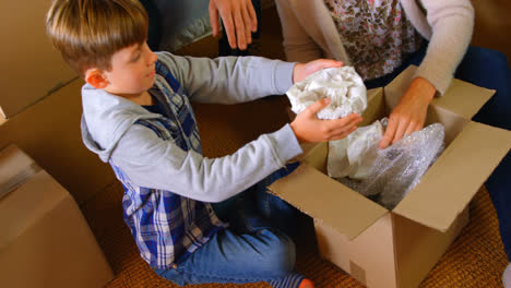 High-angle-view-of-Caucasian-son-helping-his-mother-to-packing-belongings-at-home-4k