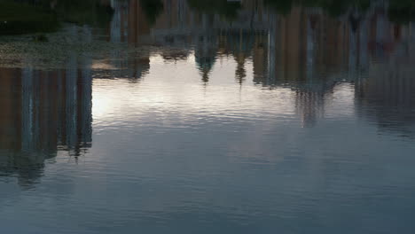 cityscape buildings reflecting water drone shot. silent river flowing slow.