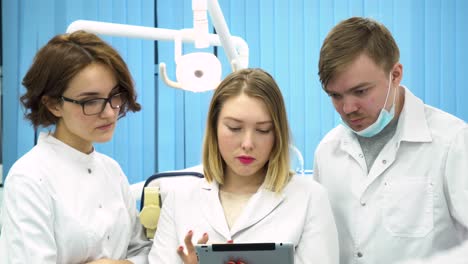 dental team discussing patient case on tablet