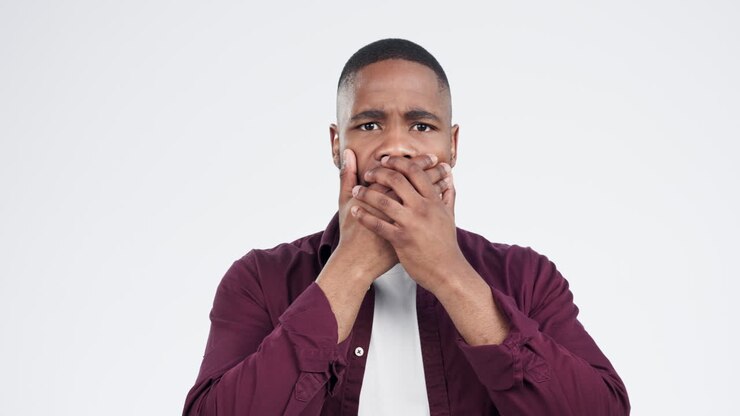 Scared, surprise and face of black man in studio
