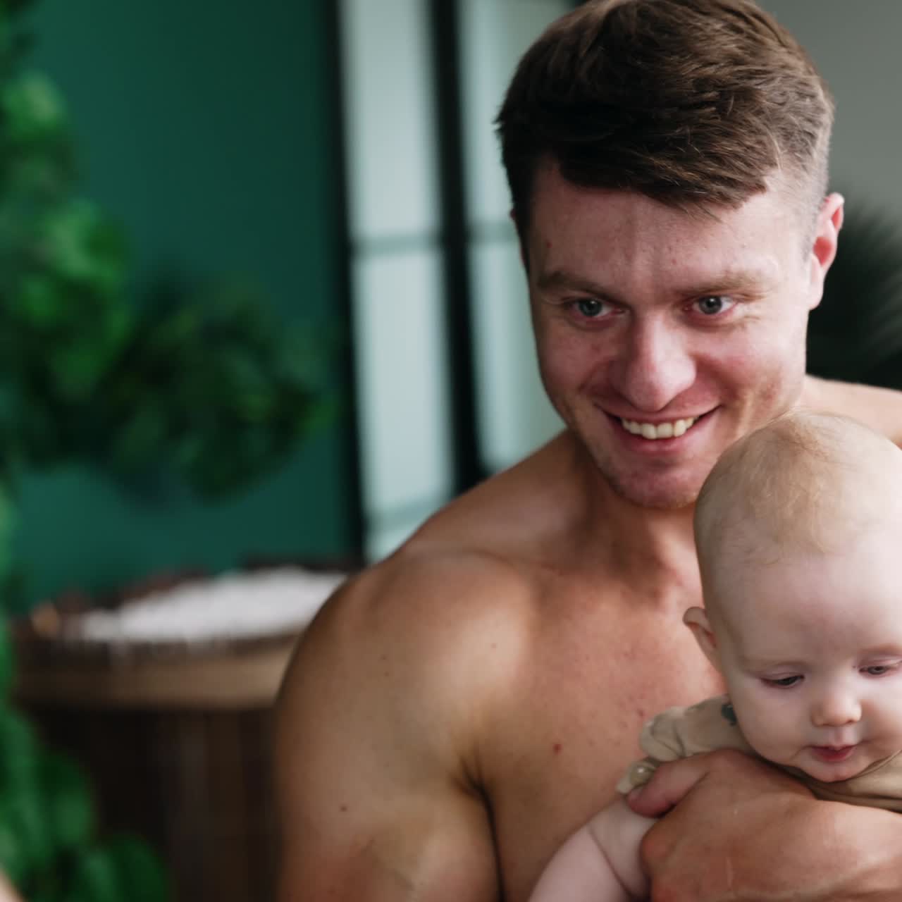 Happy dad holding his beloved baby in front of a mirror. Loving father with son family portrait. Vertical screen