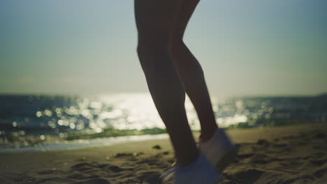 woman jumping on the beach at sunset