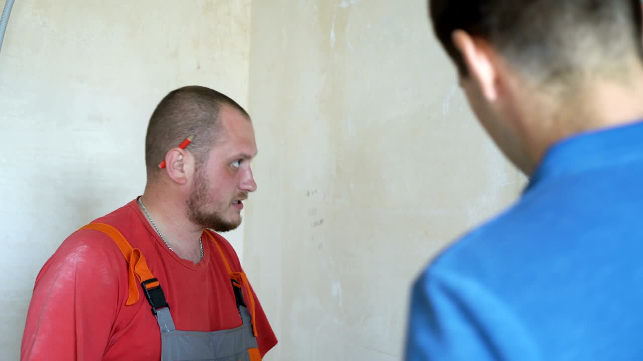 ingeniero y arquitecto discutiendo a través de una tableta inalámbrica digital trabajando en el sitio de construcción interior