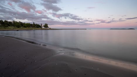 a beautiful sand beach with calmly moving water at sunset time