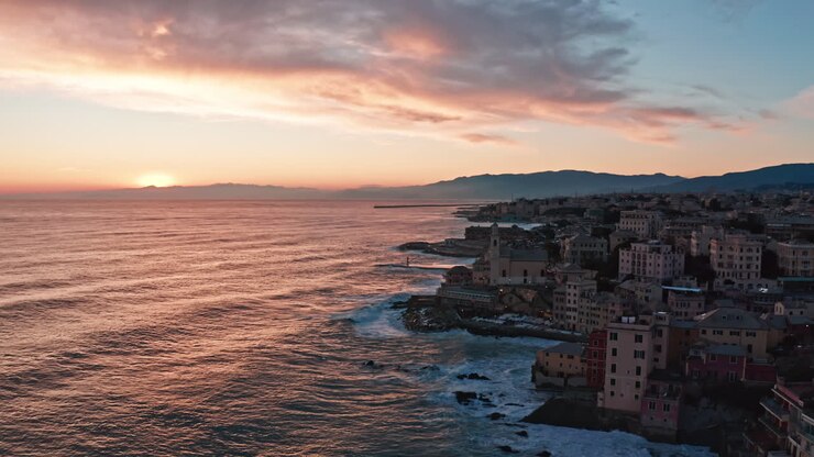 Aerial view of vibrant sunset over ocean along Boccadasse coastline in Genoa