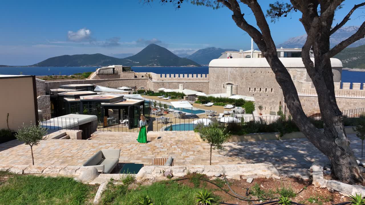 Woman Walks in Luxurious Mamula Island Hotel in Boka Bay, Aerial Track