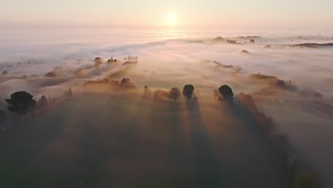 Fliegen-über-Einem-Nebligen-Morgen-In-Der-Französischen-Landschaft,-Während-Die-Sonne-Den-Nebel-Durchdringt