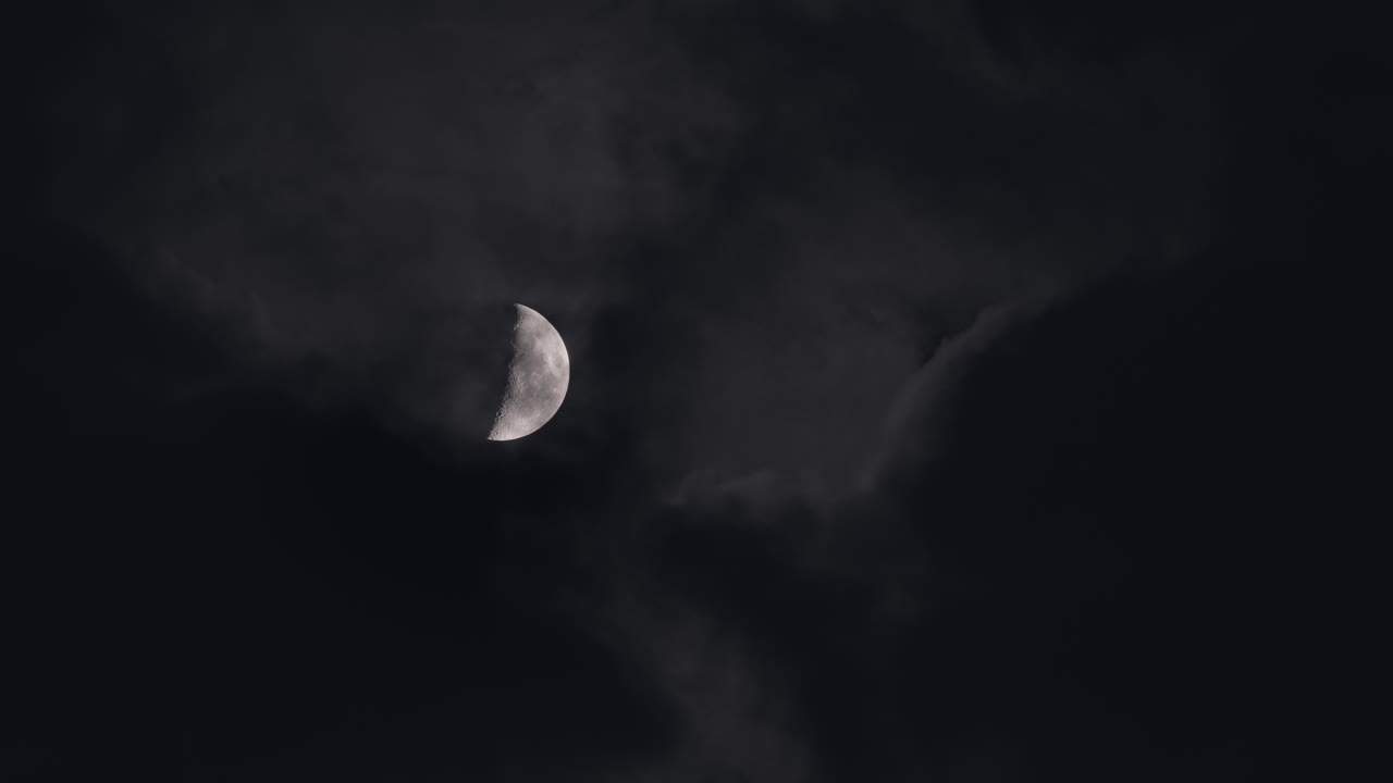 Crescent Moon Peeking Through Clouds at Night
