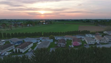 Eine-Ruhige-Vorstadt-Sonnt-Sich-Unter-Einem-Dämmrigen-Himmel,-Während-Die-Sonne-Untergeht-Und-Einen-Warmen-Schein-über-Ordentlich-Ausgerichtete-Mobile,-Vorgefertigte,-Hergestellte-Häuser-Wirft