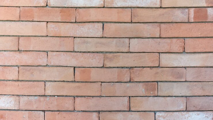 Break a wall. Red bricks installing, building wall. Concept of construction, protection, craftsmanship and module structure.