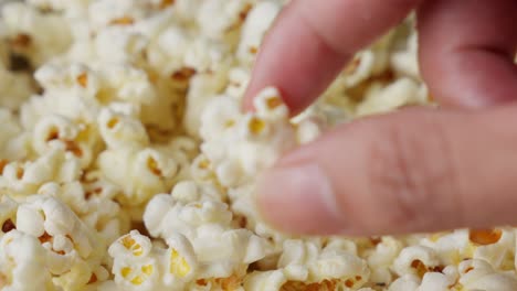 person picking popcorn and showing to camera