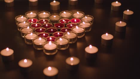 romantic red and white candles in the shape of a heart on black background 2