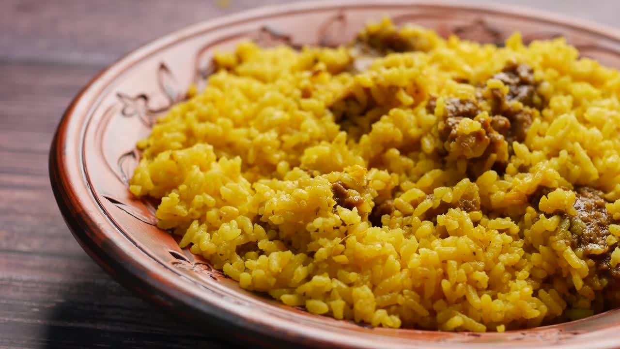 Arroz amarillo hervido con carnes en un plato
