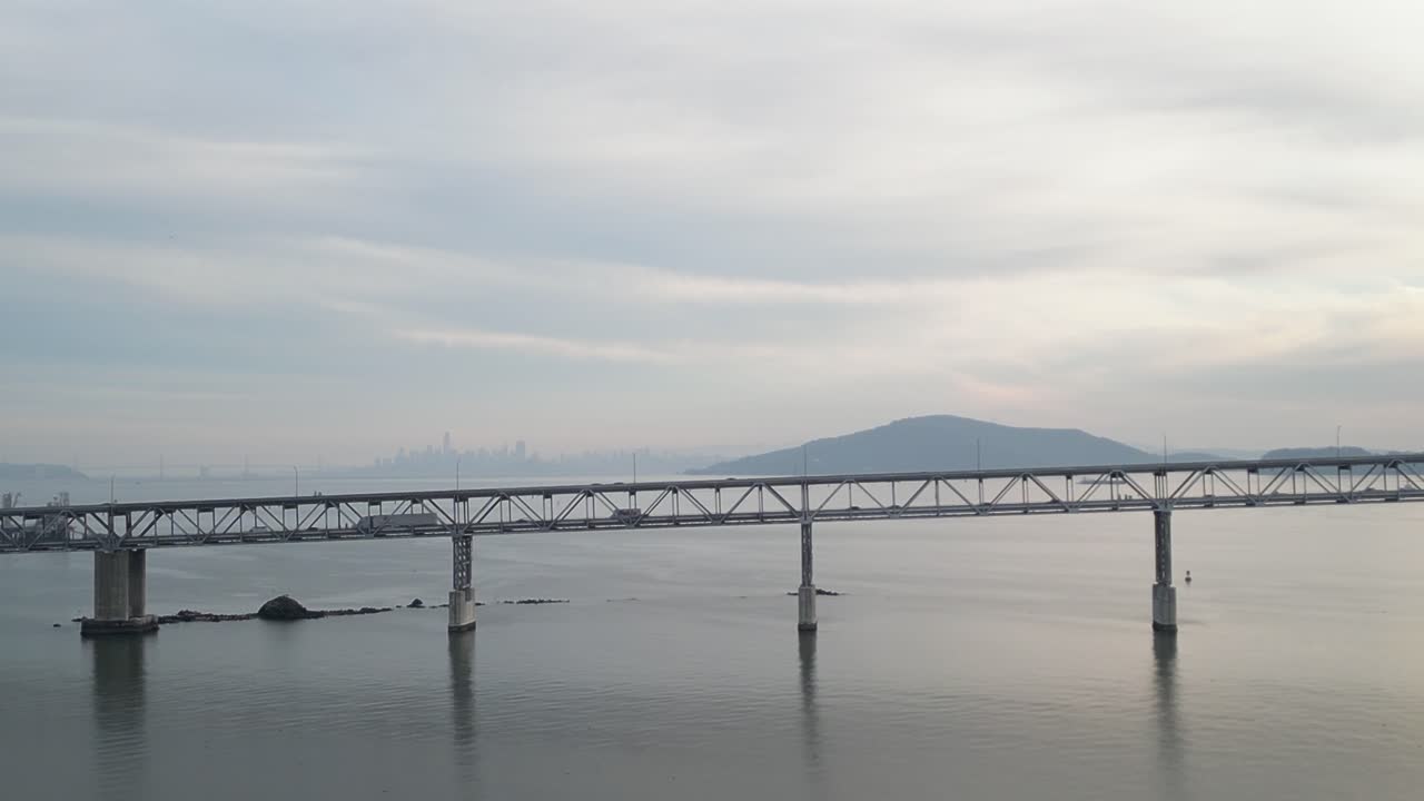 Aerial drone video captures vehicles crossing the Richmond–San Rafael Bridge near the waters of Point Molate Beach.