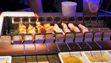 person is doing barbecue grill, rolling peaces of meat onto metal holders, video sequence captured at chengdu chinese bbq restaurant, food preparation and food lovers concept