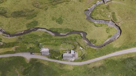 aerial view of a rural landscape with winding river, road, and house