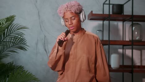 young woman pretending to sing while listening to music with closed eyes