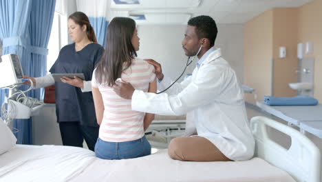 diverso médico masculino usando estetoscopio en la espalda de una paciente femenina en el hospital, espacio de copia, cámara lenta
