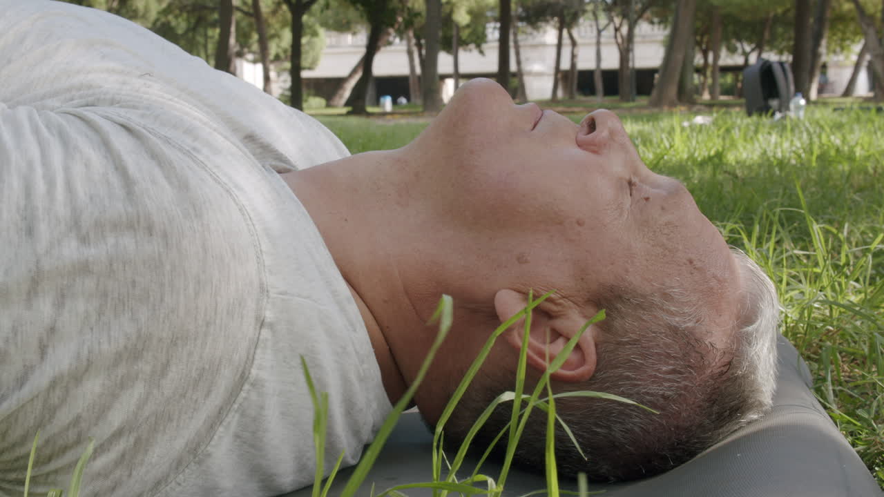 Yaşlı bir adam parkta meditasyon yapıyor.