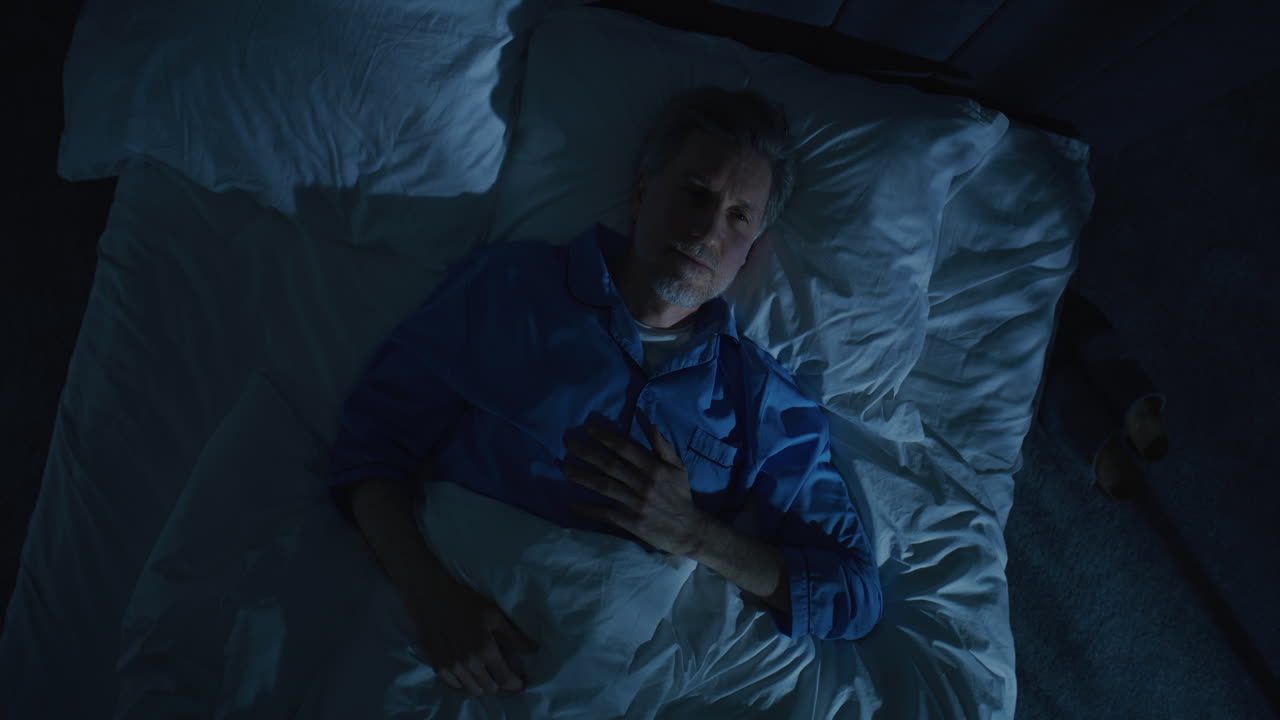 Gray Haired Mature Man Lies in Bed Unable Sleep Lost in Thoughts About Aging and Solitude
