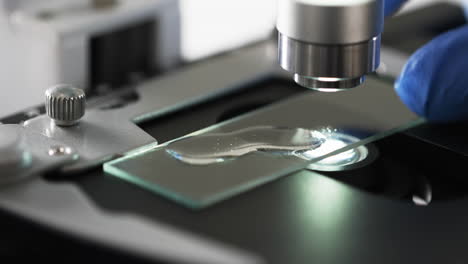 Video-of-close-up-of-scientist-using-laboratory-microscope-with-copy-space-on-white-background