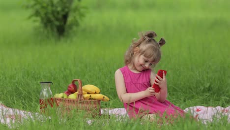 weekend at picnic. girl on grass meadow makes selfie on mobile phone. video call, blog, play games