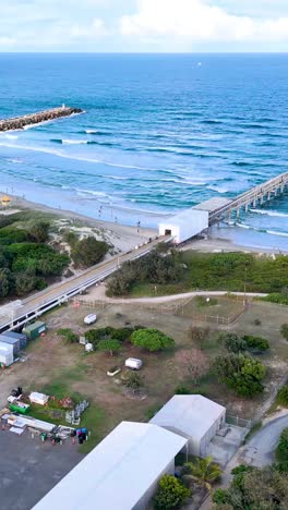 aerial view of coastal pier and beach with people