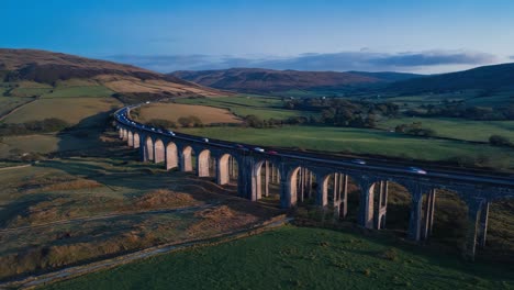 aerial view of a viaduct bridge with traffic through a green valley