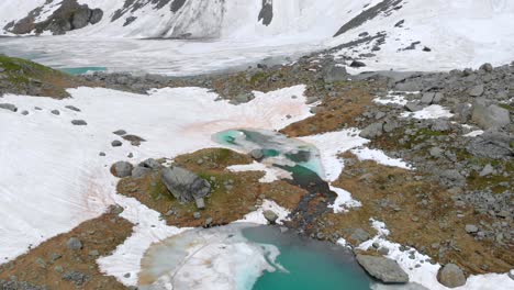 Luftaufnahme-Einiger-Zugefrorener-Seen-In-Den-Französischen-Alpen-Mit-Schneeeis-Und-Cyanfarbenem-Wasser