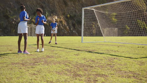 playing soccer, girls practicing on school field near goalpost, enjoying sports