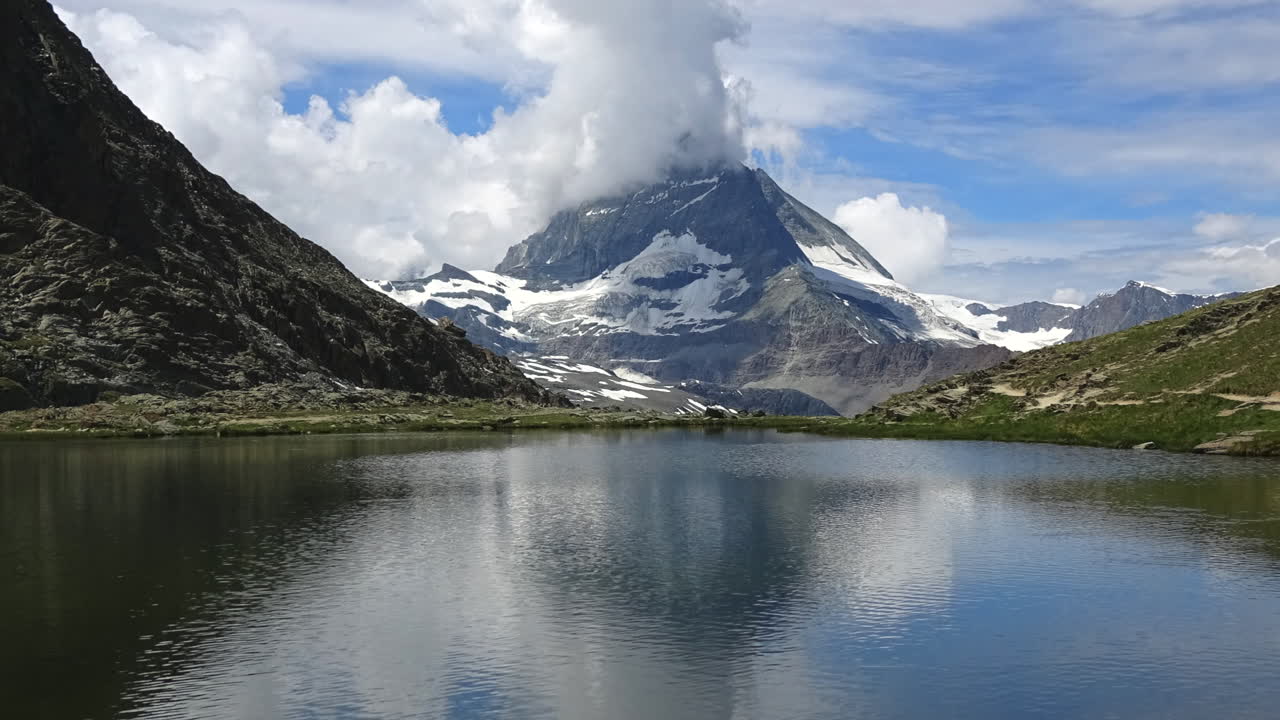 Filmato in timelapse del Cervino riflesso nel tranquillo lago Stellisee, con nuvole in movimento e paesaggio alpino vicino a Zermatt, Vallese, Svizzera, alla luce del giorno estiva.