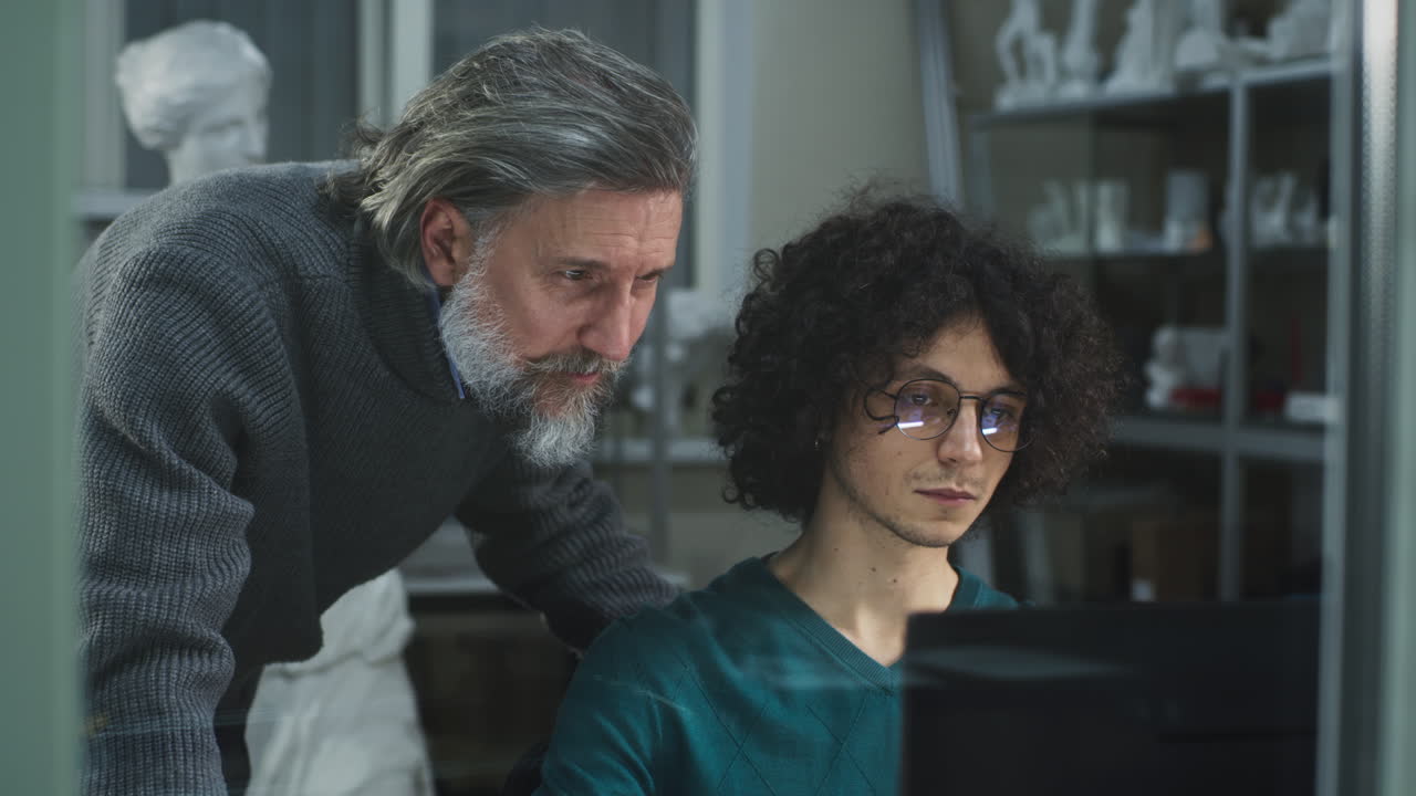 Two men collaborating and learning on a computer