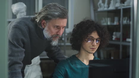 two men collaborating and learning on a computer