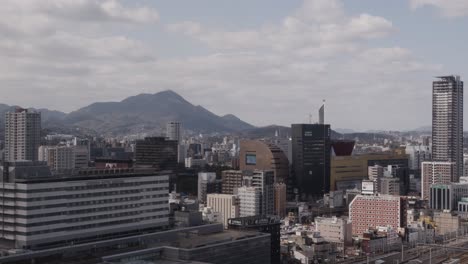 general city wide of kokura, japan with traffic, commuters, railway station and mountains