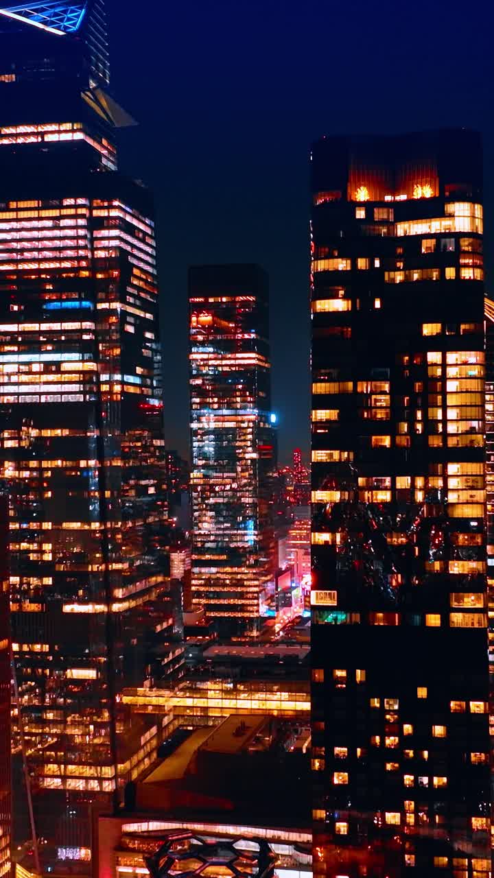 Ascensão lenta sobre os belos arranha-céus iluminados. O incrível centro de Nova York à noite, Estados Unidos.